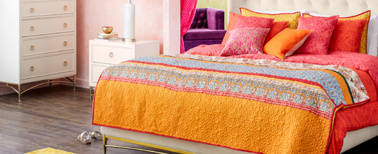 A bedroom with bedding made up in Autumn colours.