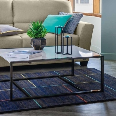 Medium sized dark blue living room carpet placed under a coffee table 